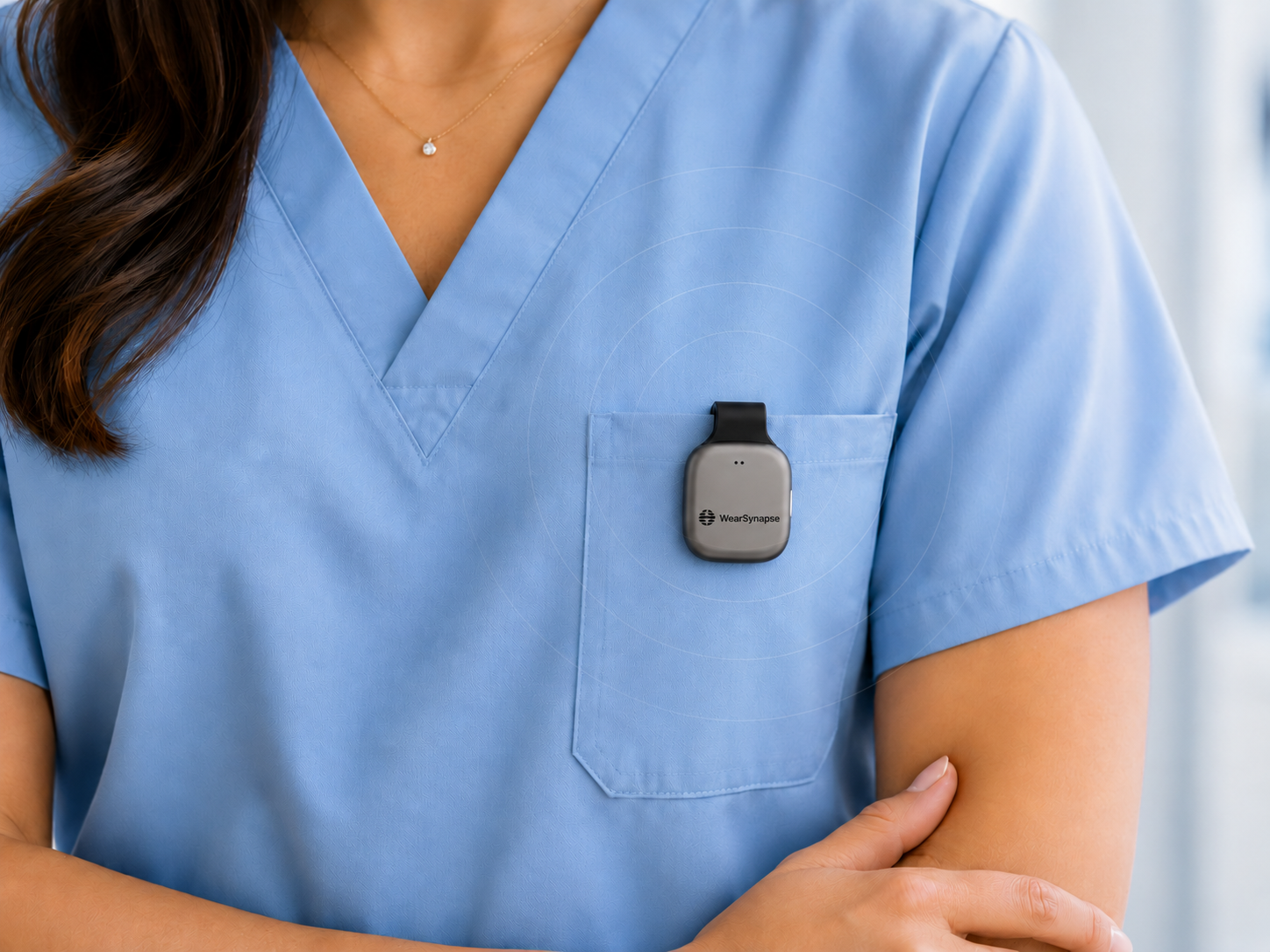 WearSynapse AI pendant clipped to a clinician's blue scrubs